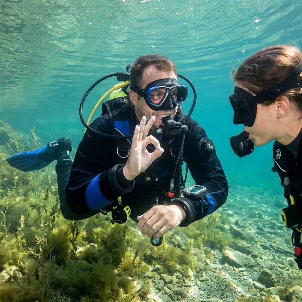 Adult diver explaining a hand signal underwater during a diving exercise
