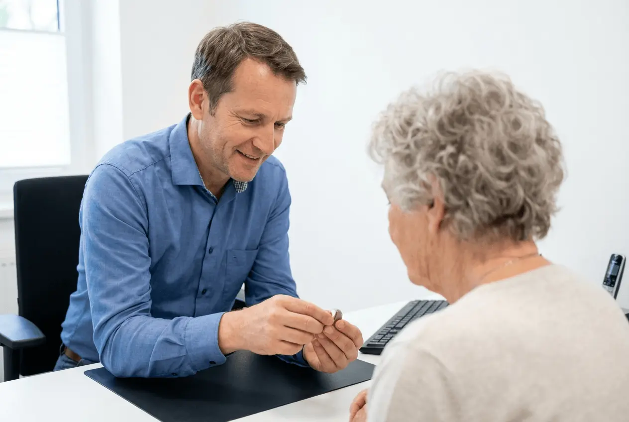 Hörakustikermeister führt professionellen Hörtest mit Patient im Fachgeschäft mit Audiometer durch